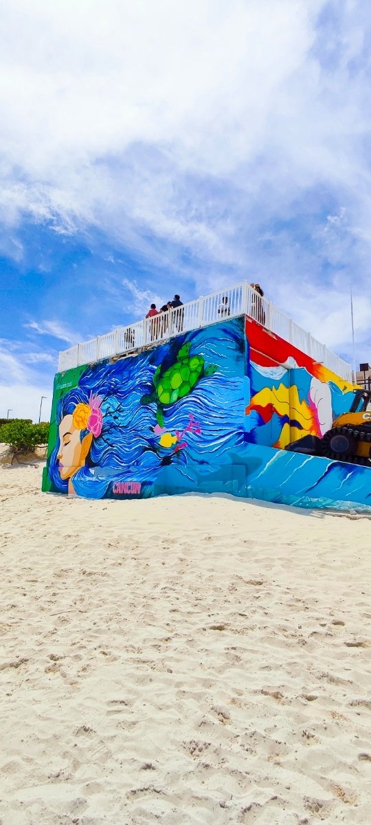 Mural colorido con temática marina adornando el mirador emblemático de Playa Delfines con un delfin y otros elementos acuáticos. © 2024 Castor Daniel Oregel Maldonado